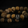 Close-up of khaki stone beaded bracelets featuring stainless-steel skull charm details