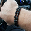 Lava Stone Skull Bracelet Set worn on wrist showing two stacked volcanic stone beaded bracelets