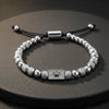 Silver beaded bracelet with a crown pattern on the plate.